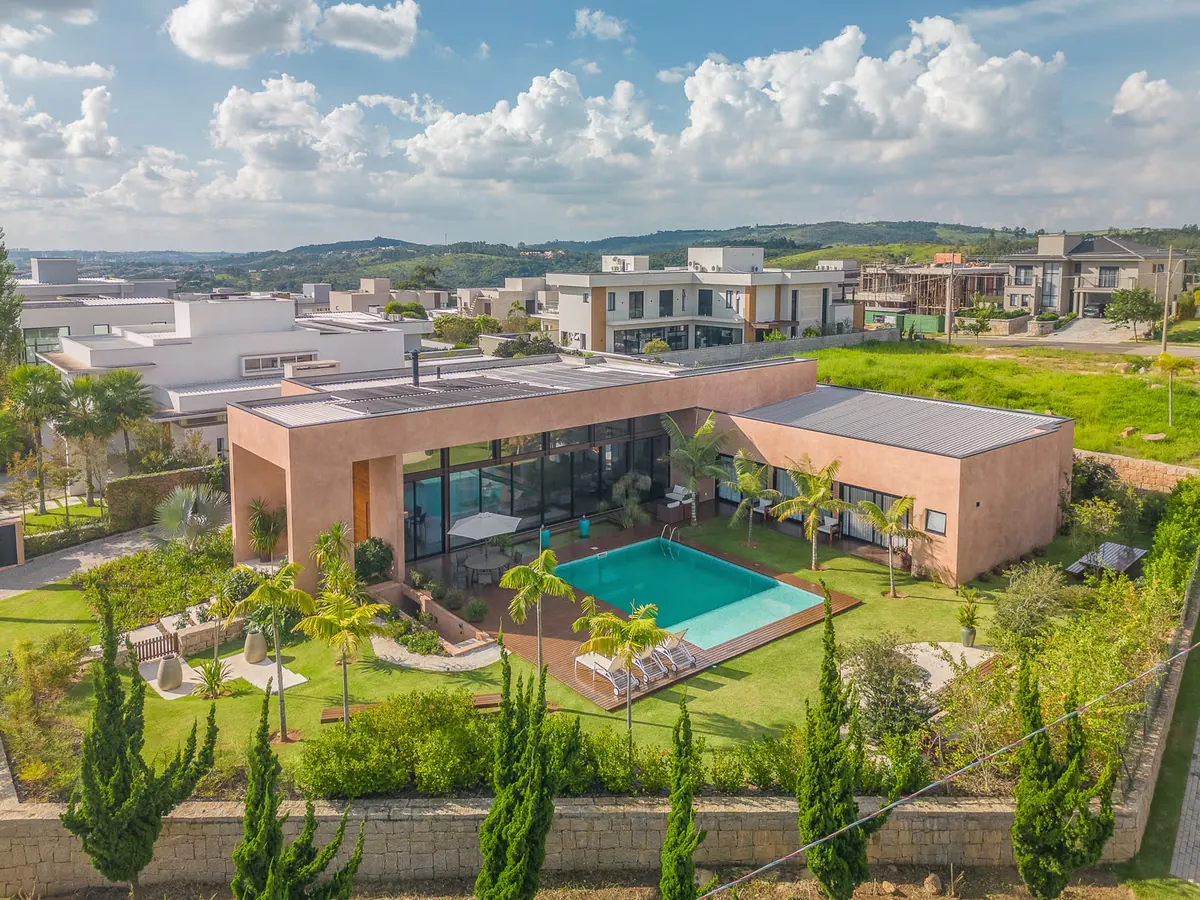 Vista aérea de casa térrea com piscina em condomínio